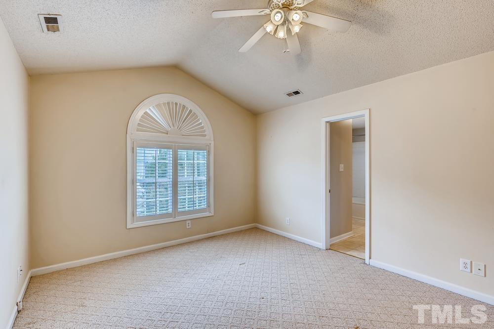 4008 Beaufain Street Raleigh, NC 27604 - Photo 16 of 30 an empty room with a chandelier fan and windows