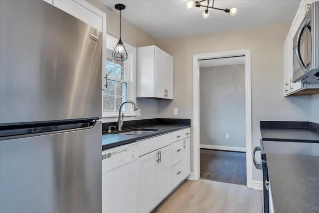 a kitchen with a refrigerator a sink and cabinets