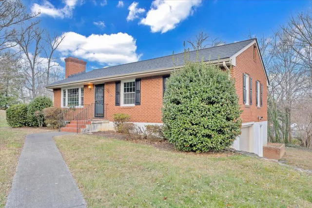 a front view of a house with a yard and potted plants