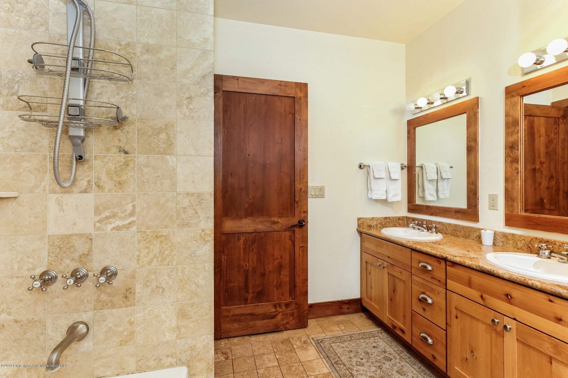 501 West Main Street, Unit A106 Aspen, CO 81611 - Photo 9 of 13 a bathroom with a granite countertop sink a mirror and a shower