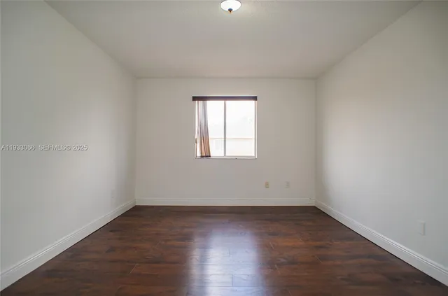 a front view of building with yard and trees