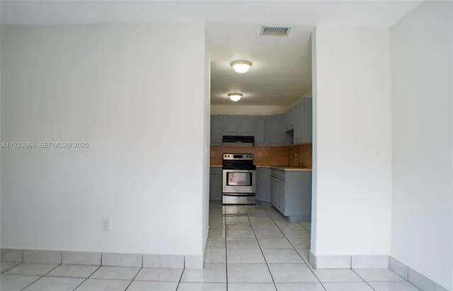 a kitchen with a refrigerator a stove top oven and cabinets