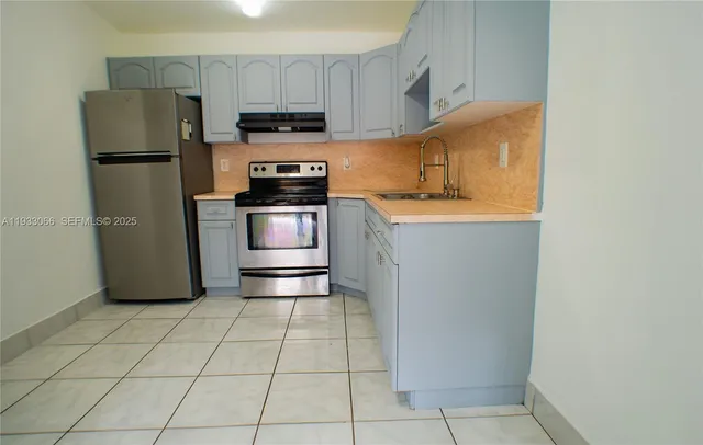a kitchen with cabinets stainless steel appliances and a sink