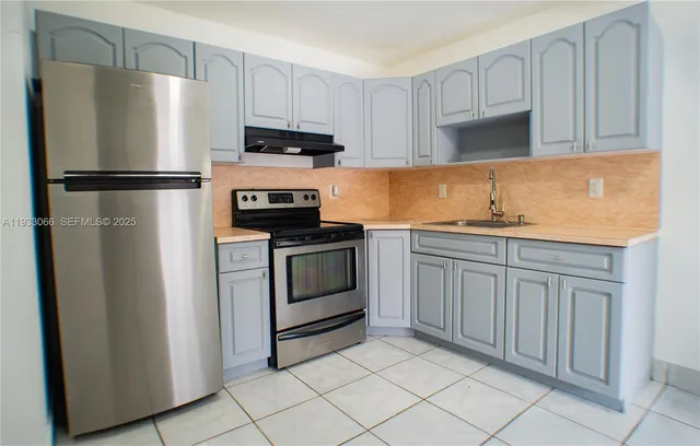 a white refrigerator freezer and a stove sitting inside of a kitchen