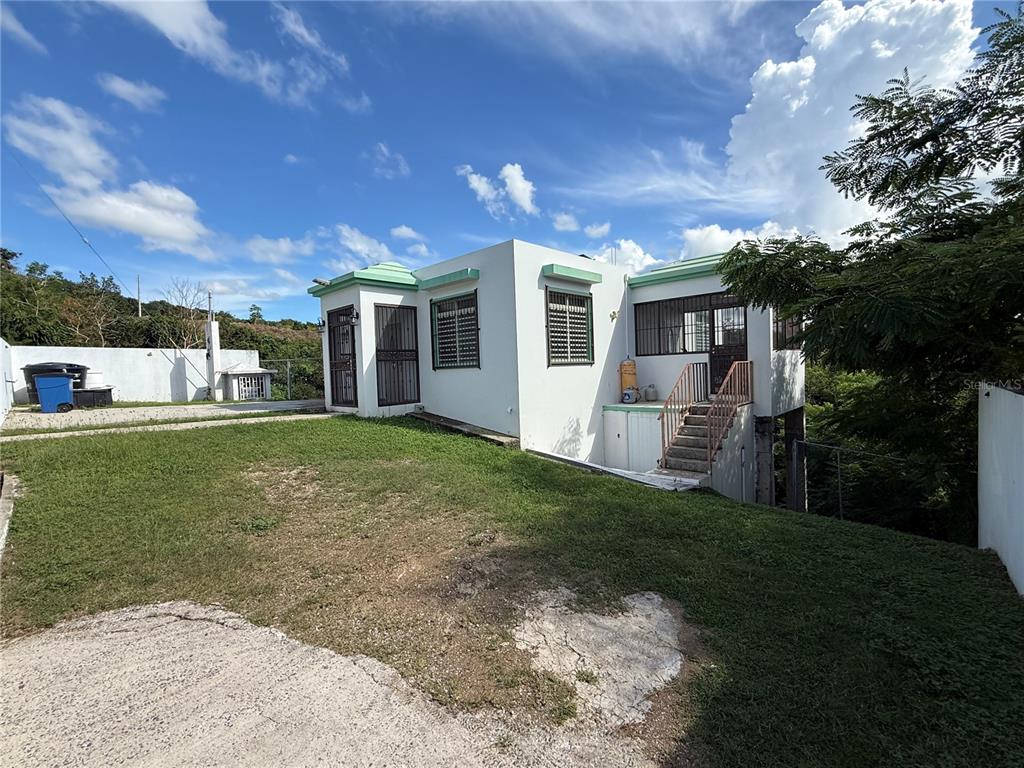 411 Bo Calvache Rincon, PR 00677 - Photo 2 of 14 a front view of a house with a yard and trees