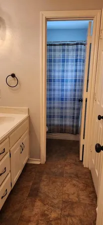 a bathroom with a granite countertop sink a toilet and shower