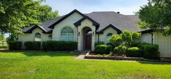 a front view of a house with yard and green space