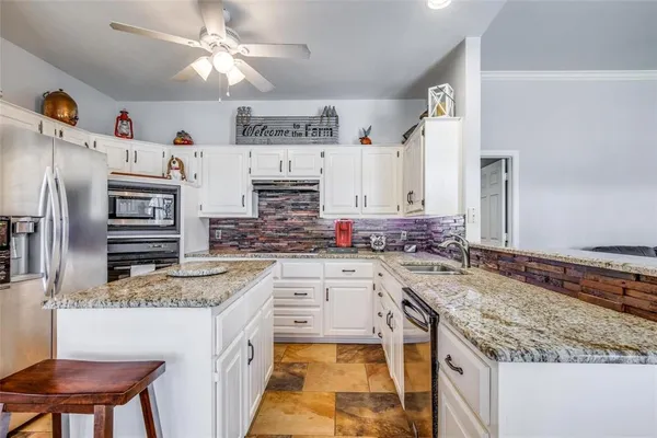 a kitchen with stainless steel appliances granite countertop a sink stove and refrigerator