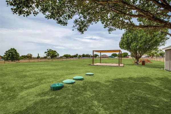 a view of a yard in front of a house with large tree