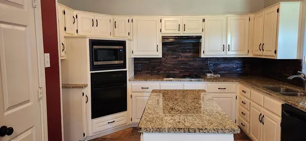 a kitchen with stainless steel appliances granite countertop a refrigerator and a stove