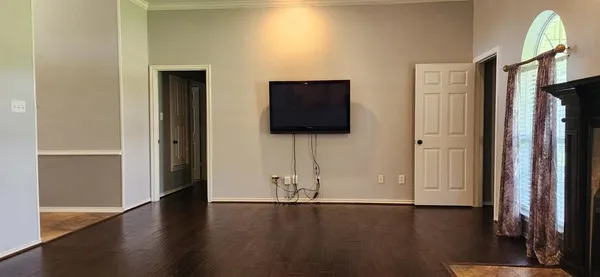 a view of a livingroom with wooden floor and a flat screen tv