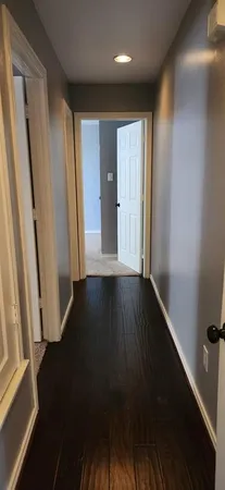 a view of hallway with wooden floor and stairs