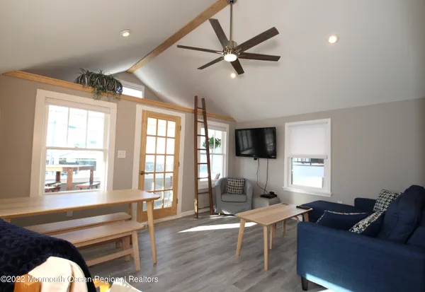 a kitchen with stainless steel appliances granite countertop a refrigerator a sink dishwasher a stove and white countertops with wooden floor