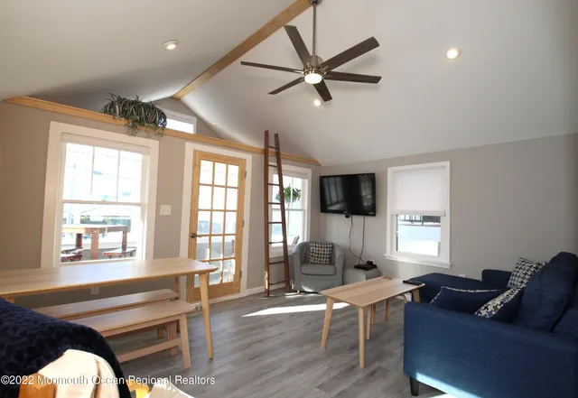 a kitchen with stainless steel appliances granite countertop a refrigerator a sink dishwasher a stove and white countertops with wooden floor