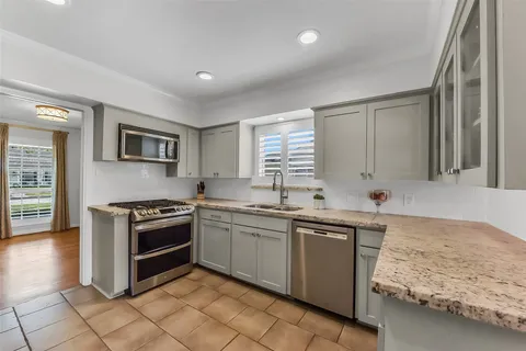 a kitchen with stainless steel appliances granite countertop a sink stove and cabinets