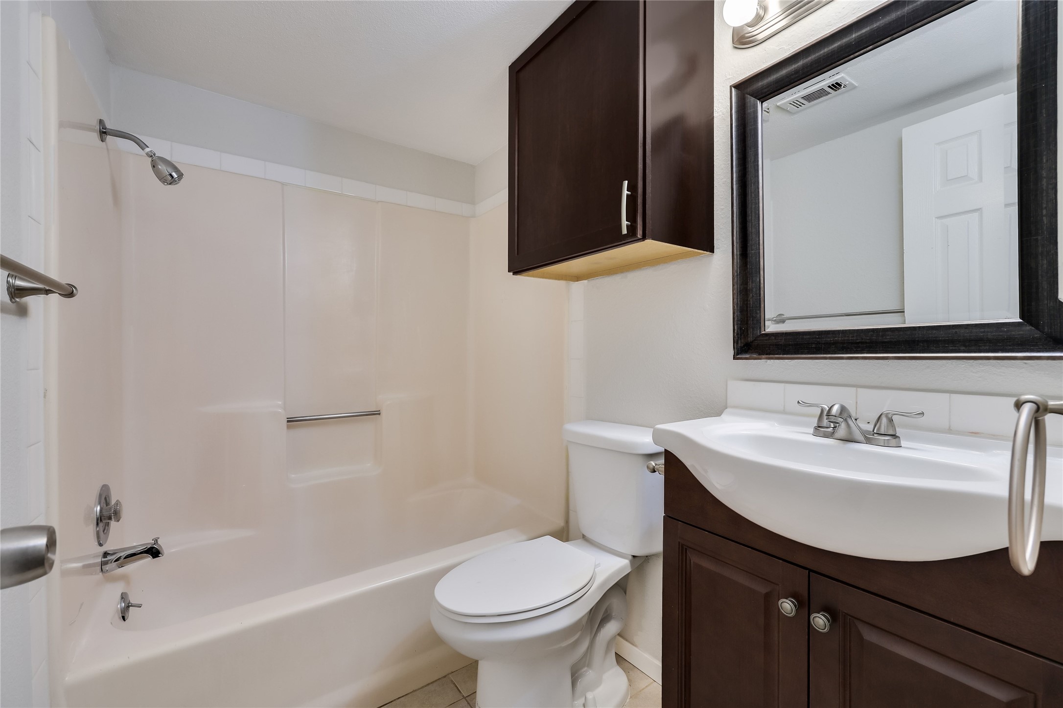 2500 Burleson Road, Unit 609 Austin, TX 78741 - Photo 7 of 32 A compact full bath features a shower-tub combo, modern vanity, and dark wood cabinetry.