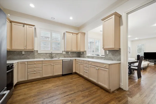 a large kitchen with granite countertop a stove a sink and white cabinets