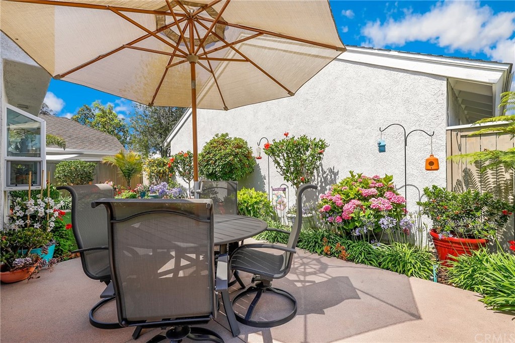 14 Wintermist, Unit 83 Irvine, CA 92614 - Photo 38 of 45 a patio with a table and chairs under an umbrella