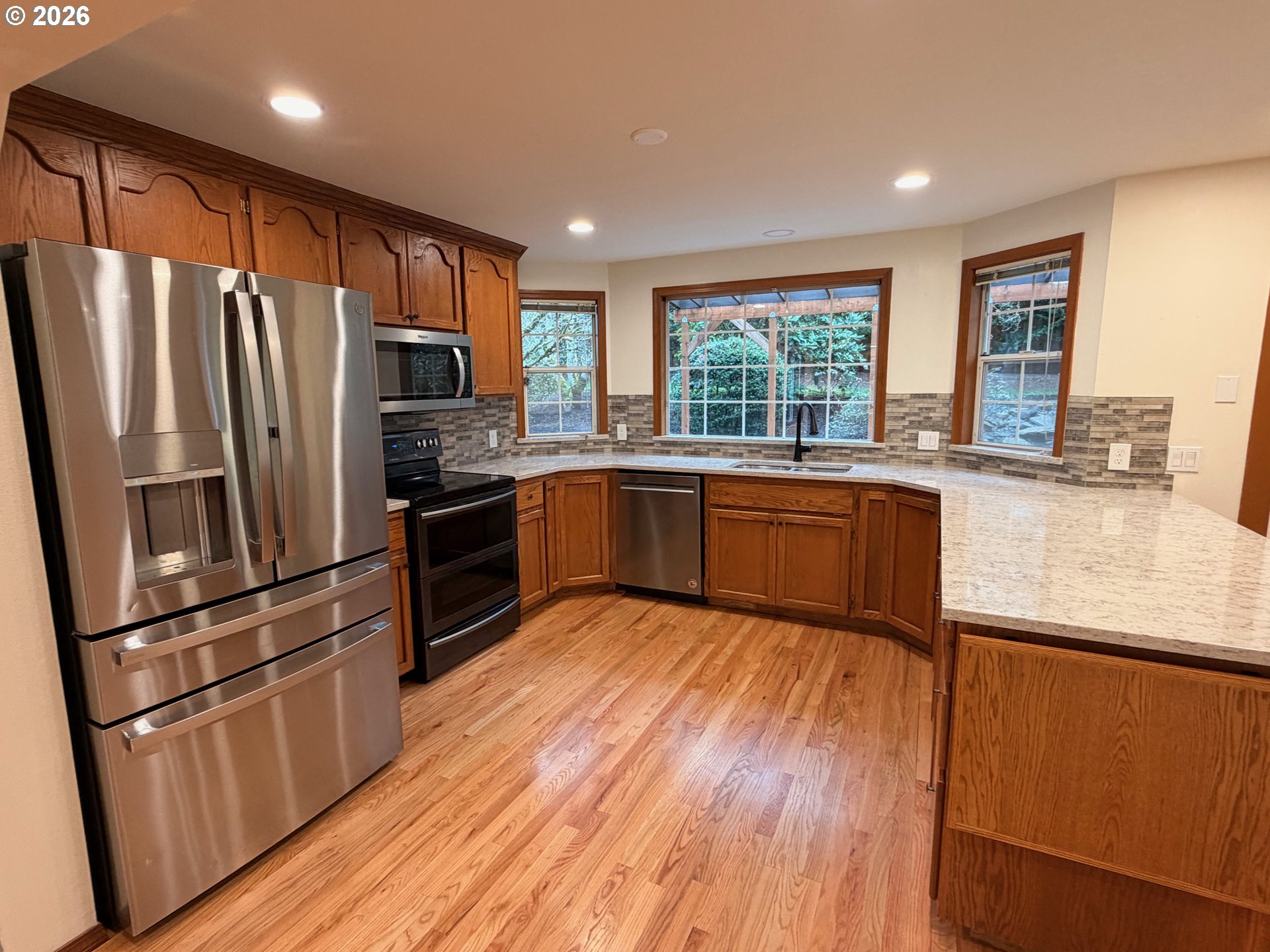 7505 Southwest Schroeder Way Wilsonville, OR 97070 - Photo 2 of 24 a kitchen with granite countertop stainless steel appliances a sink a refrigerator a window and cabinets