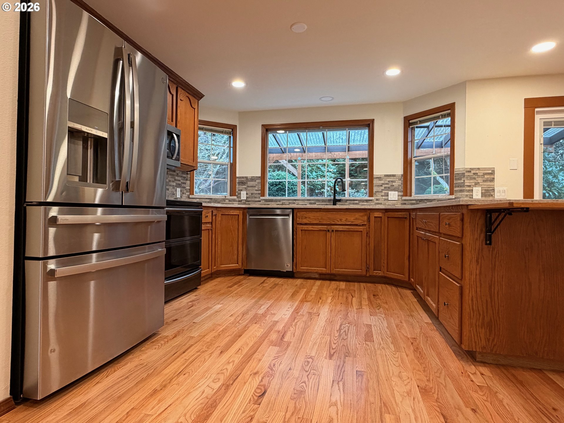 7505 Southwest Schroeder Way Wilsonville, OR 97070 - Photo 4 of 24 a kitchen with stainless steel appliances granite countertop a refrigerator a sink dishwasher and wooden floor