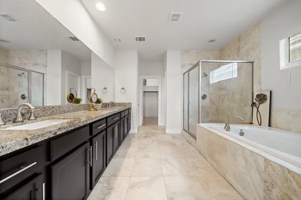 a spacious bathroom with a granite countertop tub sink and mirror