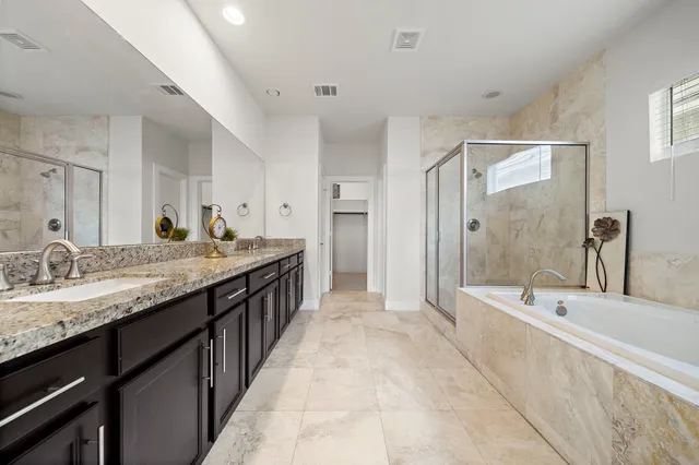 a spacious bathroom with a granite countertop tub sink and mirror