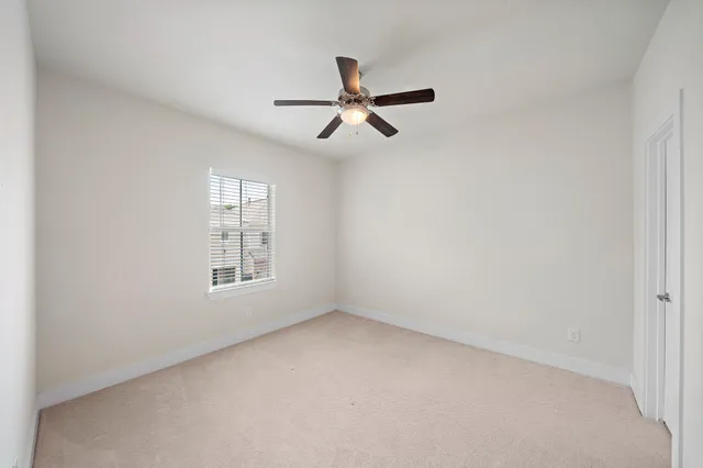 an empty room with a window and a fan