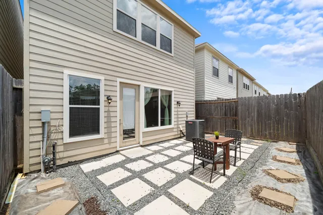 a view of a patio with table and chairs and wooden fence