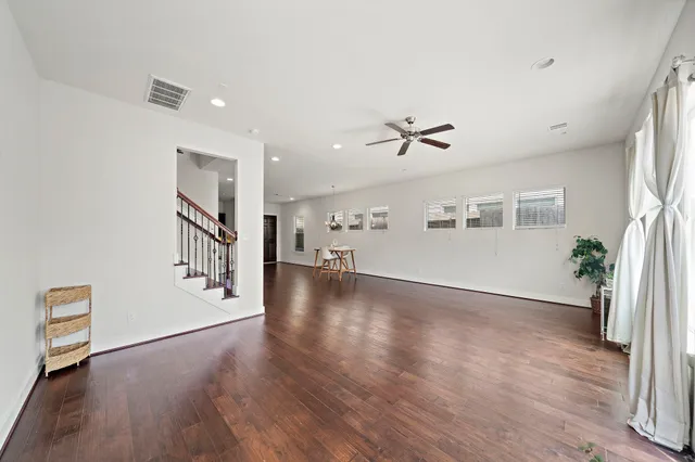 a view of a livingroom with wooden floor and a ceiling fan