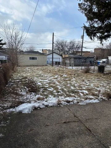 a view of a yard with wooden fence