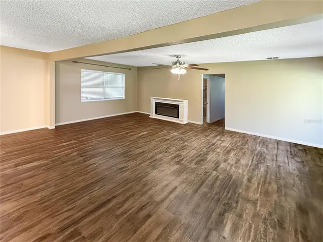 a view of a livingroom with wooden floor and a ceiling fan