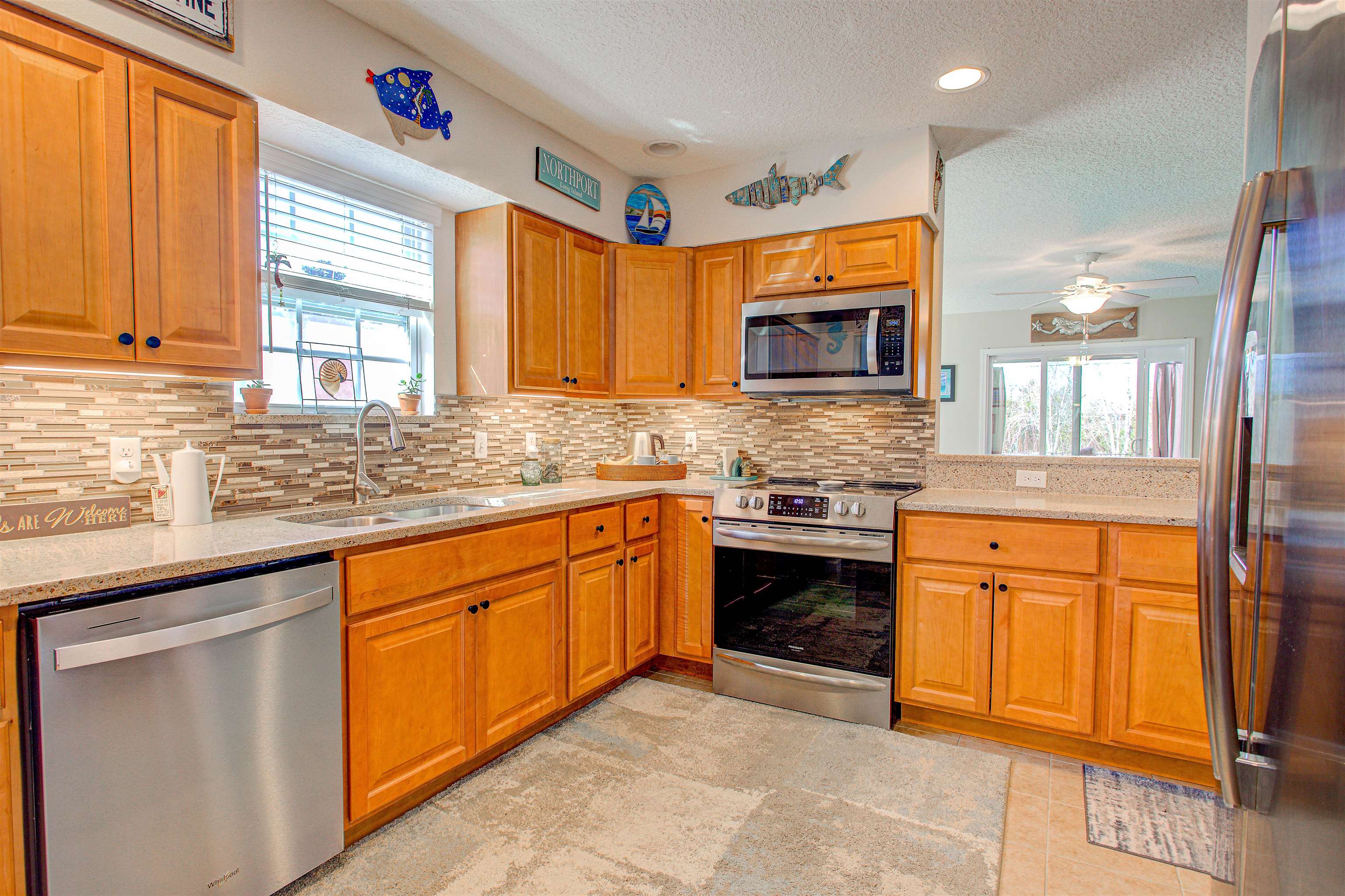 292 North Twin Maple Road St. Augustine, FL 32084 - Photo 44 of 79 a kitchen with stainless steel appliances granite countertop wooden cabinets a stove top oven a sink and dishwasher next to a window