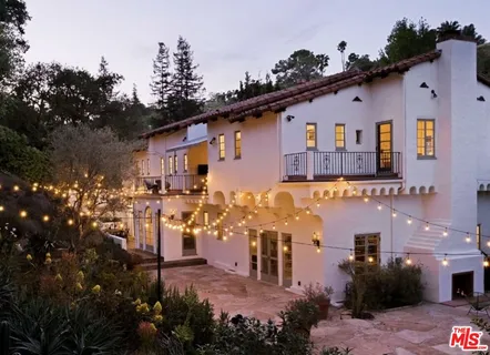 a front view of house with a yard and trees around