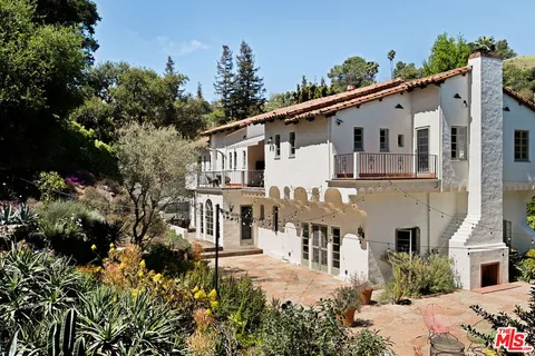 a view of a house with a yard and potted plants