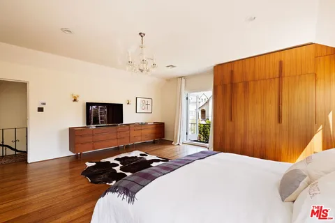 a bedroom with a large bed and wooden floor