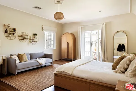 a view of a white house with a big yard and potted plants