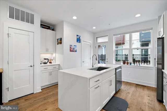 a kitchen with white cabinets and sink