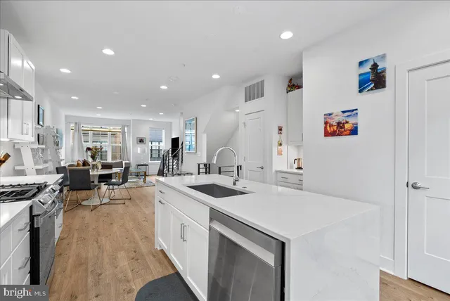 a kitchen with a sink a stove and chairs