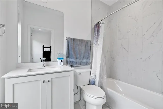 a bathroom with a sink toilet vanity and shower