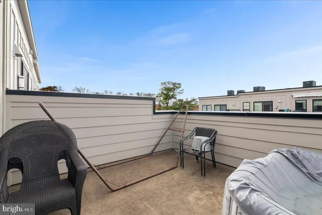 a roof deck with couches and potted plants