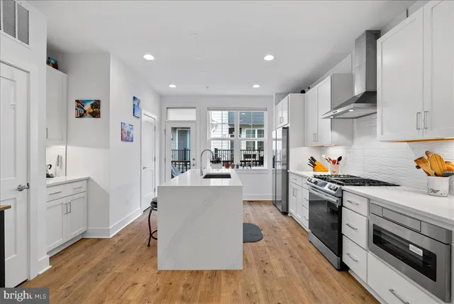 a kitchen with white cabinets and stainless steel appliances