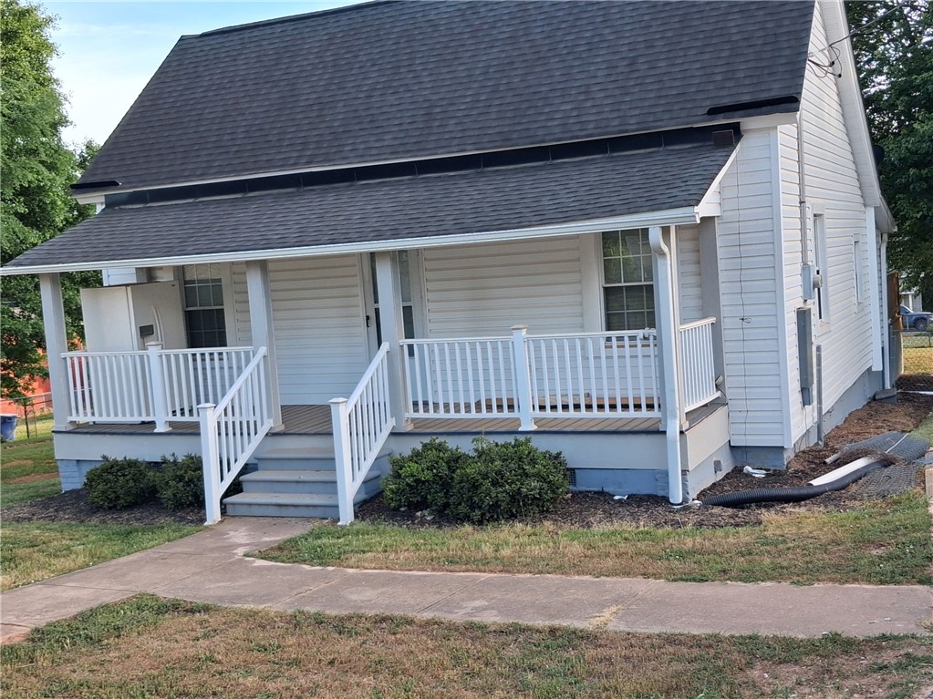 This charming home offers a welcoming facade with a covered front porch, perfect for outdoor enjoyment.