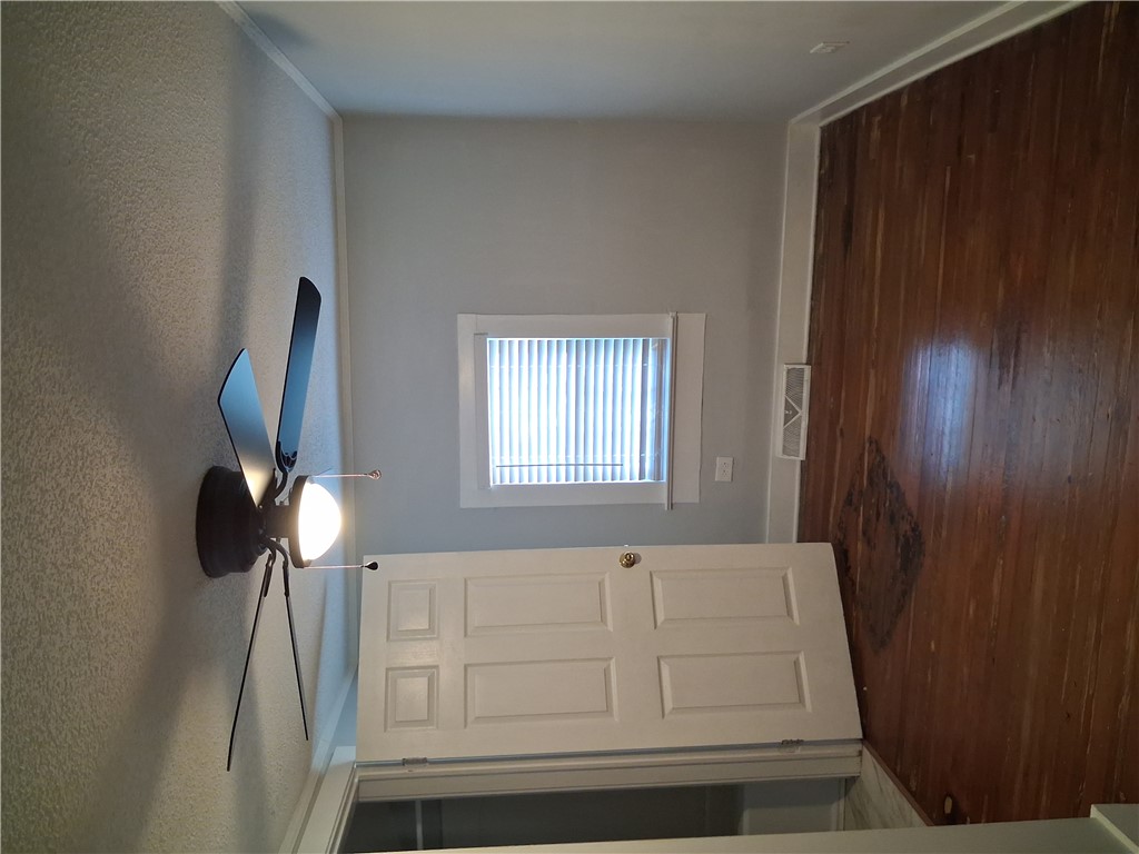 6 Allen Street Pelzer, SC 29669 - Photo 8 of 13 This interior hallway features hardwood flooring and a ceiling fan, providing comfort and natural light.