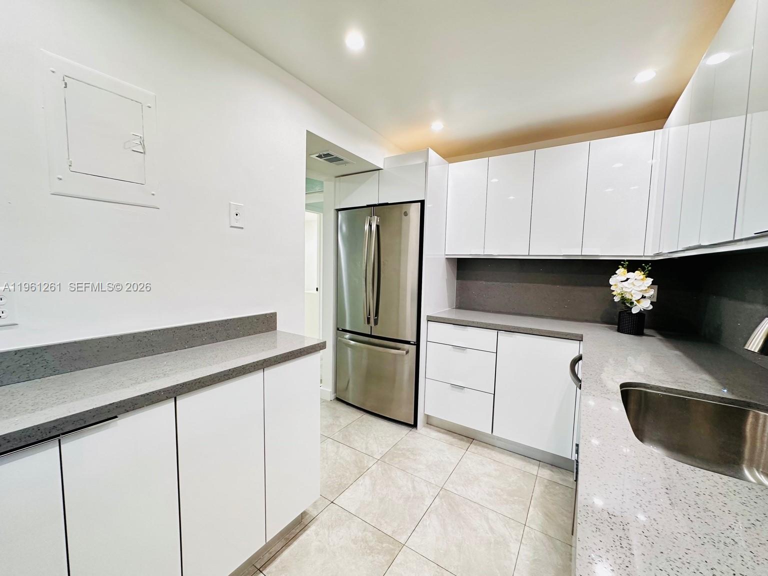3490 Foxcroft Road, Unit B208 Miramar, FL 33025 - Photo 11 of 32 a kitchen with stainless steel appliances a refrigerator sink and cabinets