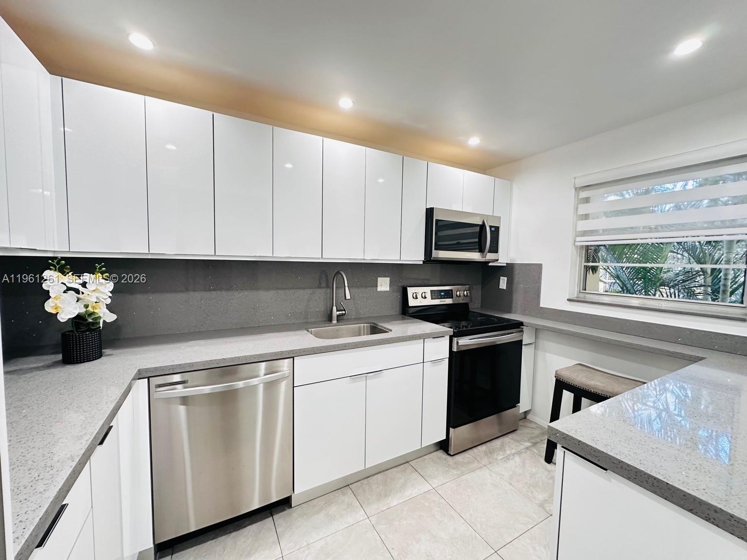 3490 Foxcroft Road, Unit B208 Miramar, FL 33025 - Photo 12 of 32 a kitchen with cabinets appliances and a sink