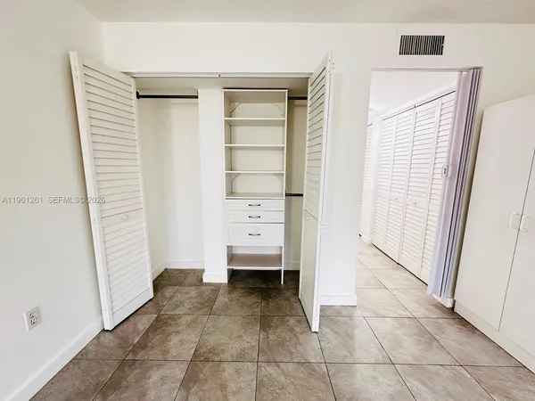 a view of walk in closet with empty racks