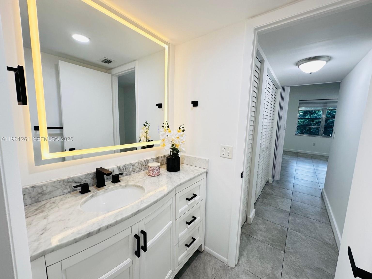 3490 Foxcroft Road, Unit B208 Miramar, FL 33025 - Photo 20 of 32 a bathroom with a double vanity sink and mirror