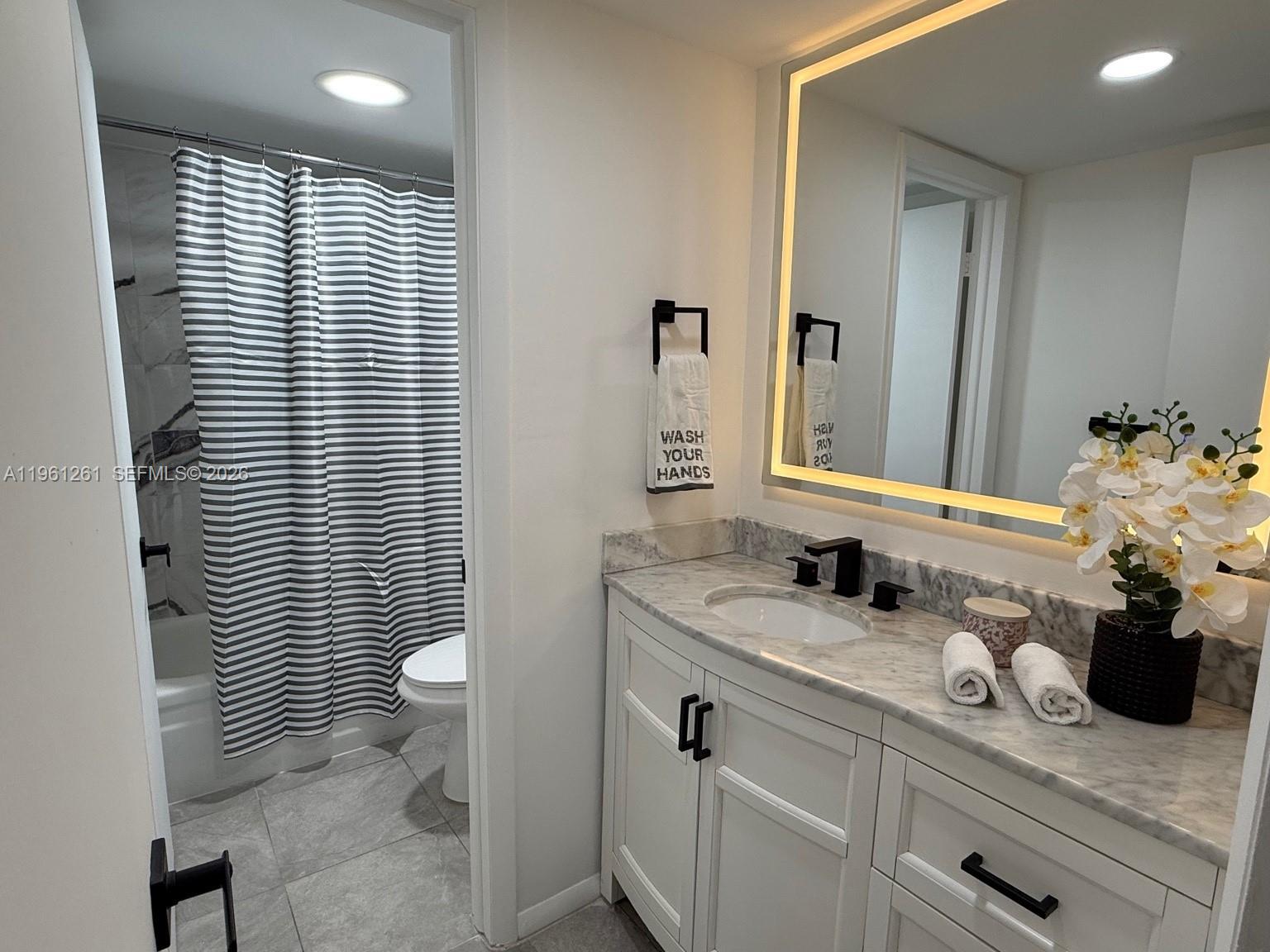 3490 Foxcroft Road, Unit B208 Miramar, FL 33025 - Photo 21 of 32 a bathroom with a granite countertop sink a toilet and mirror