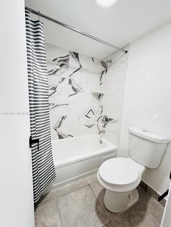 a white toilet sitting next to a bath tub