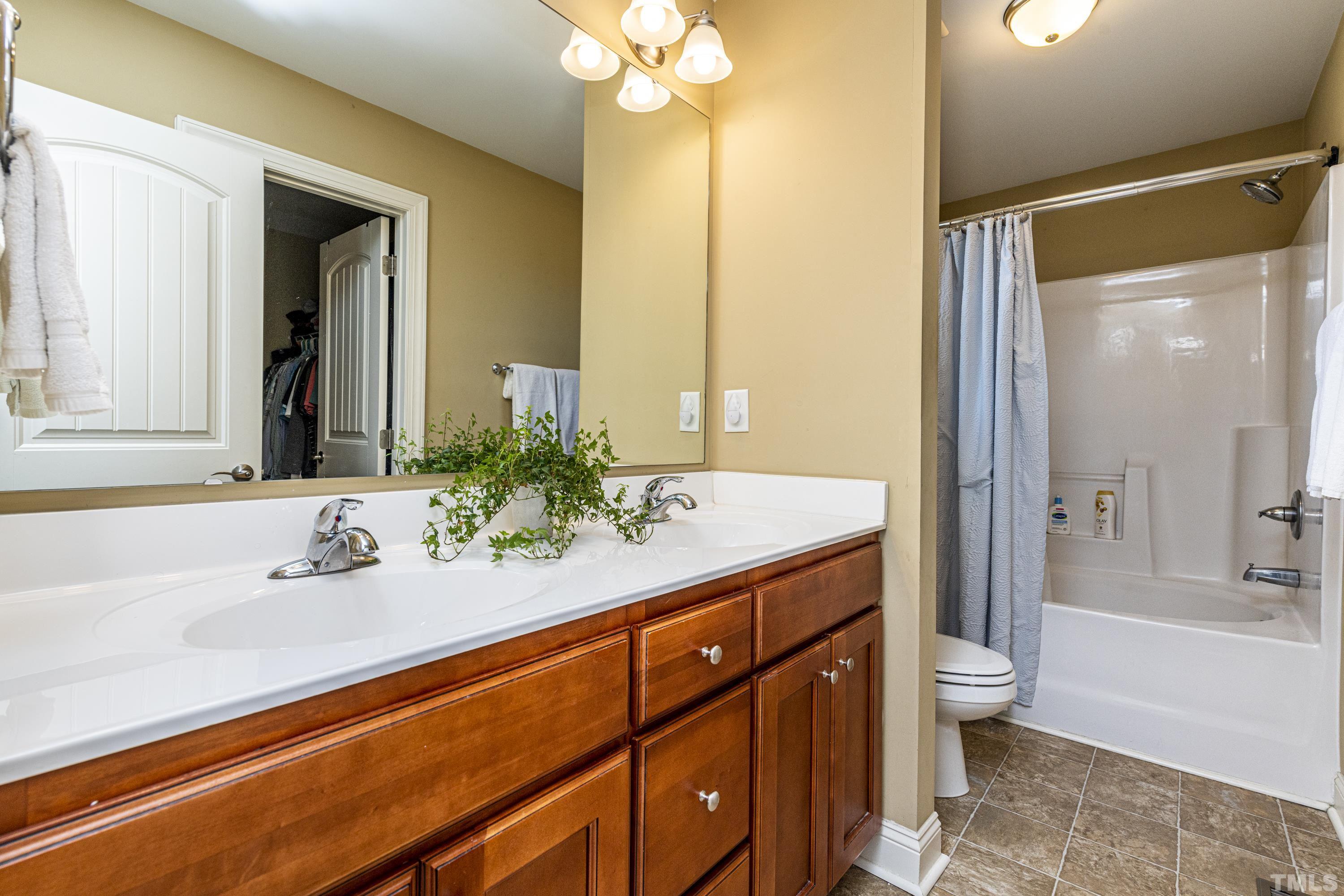 312 Wick Road Stem, NC 27581 - Photo 20 of 34 a bathroom with a sink a toilet and a large mirror